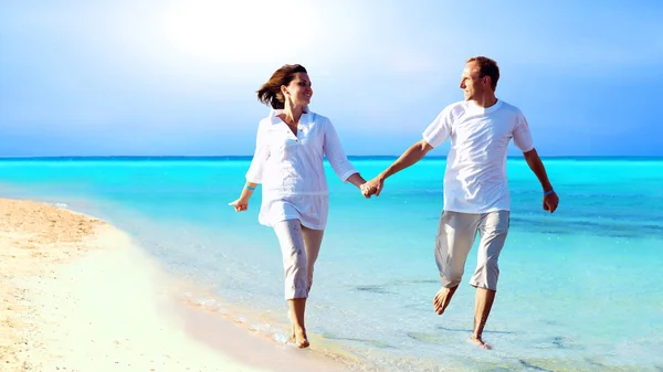 Pohled na šťastný mladý pár na pláži, drželi se za ruce. — Stock fotografie