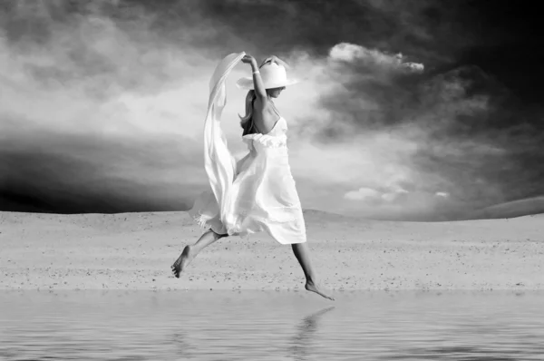 日当たりの良い砂漠で水にジャンプ、白の若い美しい女性 — ストック写真