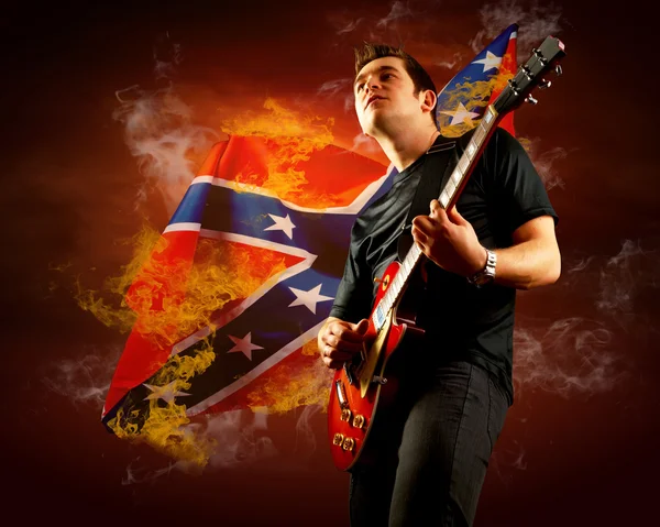 Rock gitarrist spelar på elgitarr runt eld lågor — Stockfoto