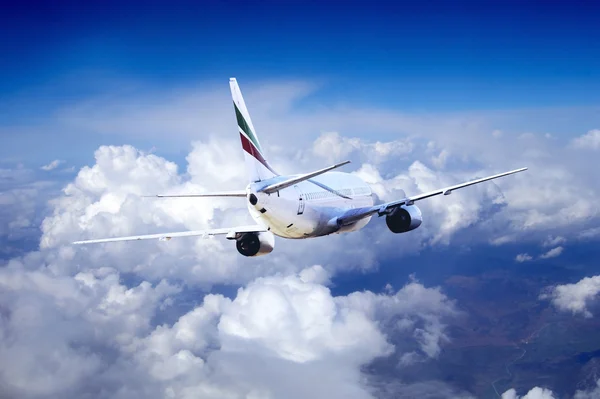 Літак летить на небі з хмарами — стокове фото