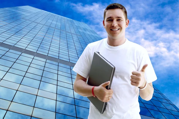 Giovane uomo felice o studente con computer portatile e telefono sul business — Foto Stock