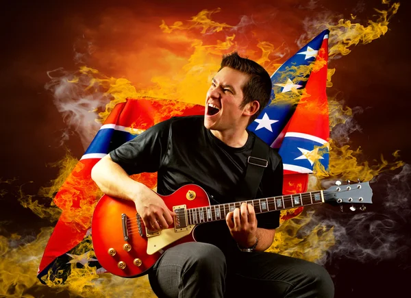 Ροκ κιθαρίστας παιχνίδι στην ηλεκτρική κιθάρα γύρω από τις φλόγες της φωτιάς — Φωτογραφία Αρχείου