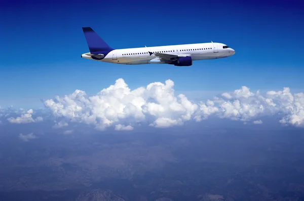 Flygplan på fluga på himlen med moln — Stockfoto