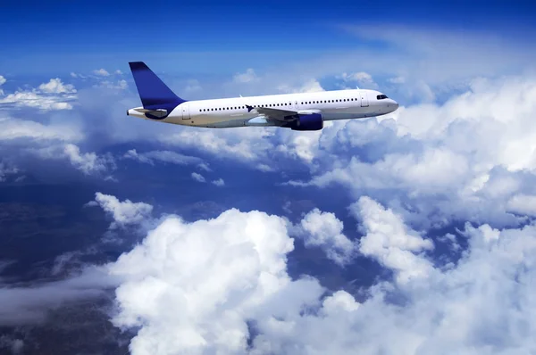Flygplan på fluga på himlen med moln — Stockfoto