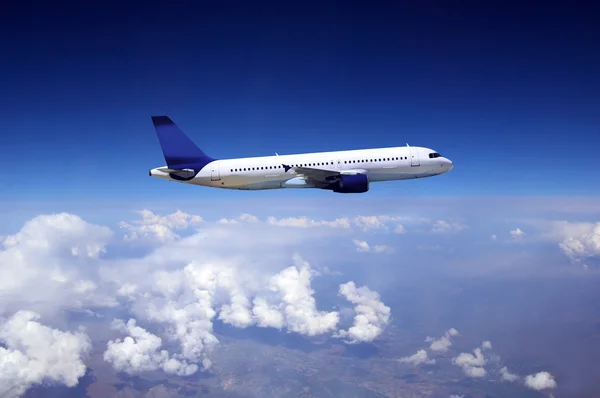 Літак летить на небі з хмарами — стокове фото