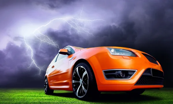 Belle voiture de sport orange sur ciel sombre avec la foudre — Photo