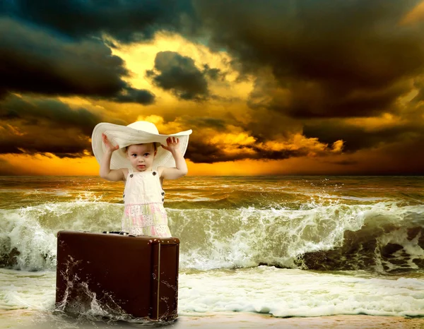 Маленький ребенок с багажом на тропическом пляже — стоковое фото