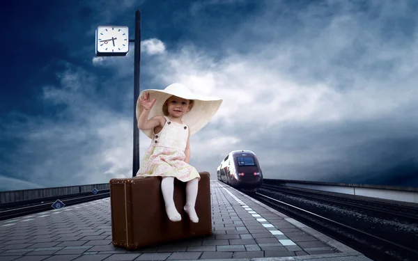 Kleines Mädchen sitzt auf Vintage-Gepäck auf dem Bahnsteig von — Stockfoto