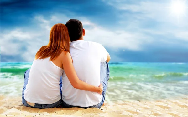 Vista mare di una coppia seduta sulla spiaggia . — Foto Stock