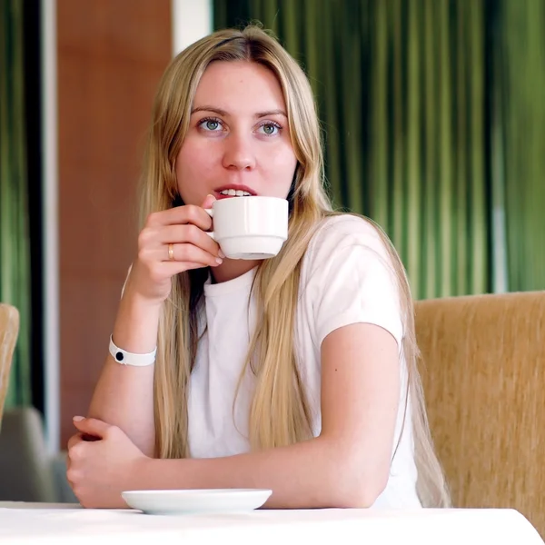 Glad kvinna i vitt med kopp kaffe eller te. — Stockfoto