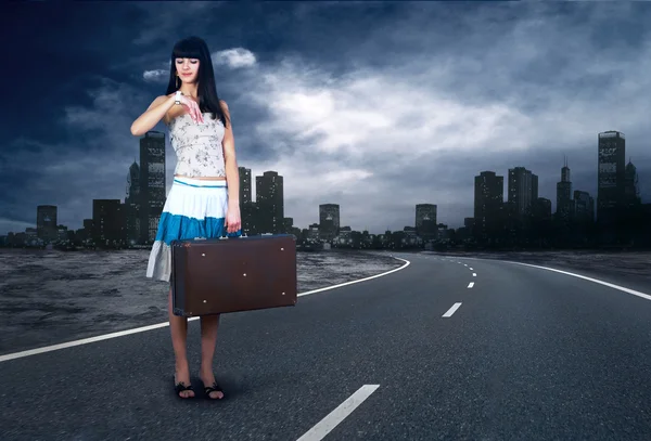 Jonge vrouw te wachten op de weg met haar vintage Bagage — Stockfoto