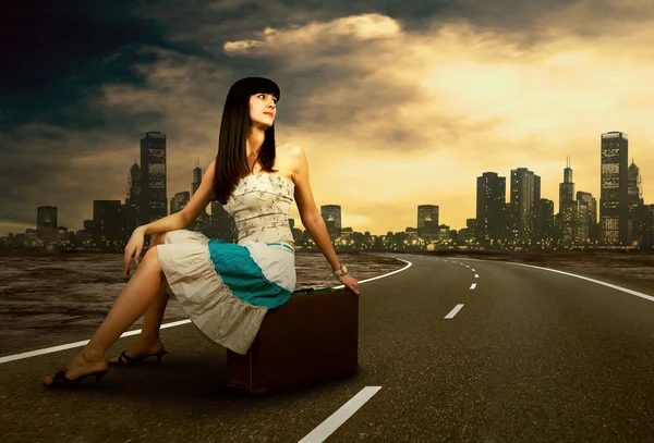 Fiatal nő az úton, ő vintage poggyásszal vár — Stock Fotó