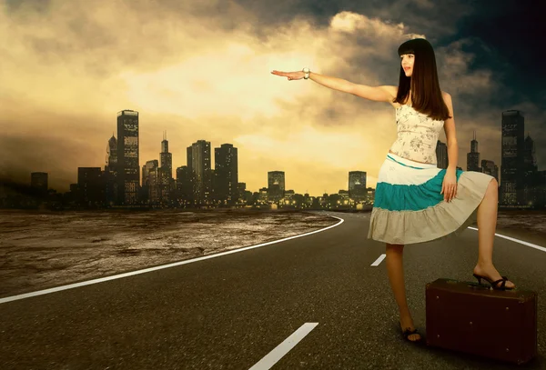 Jeune femme qui attend sur la route avec son bagage vintage — Photo