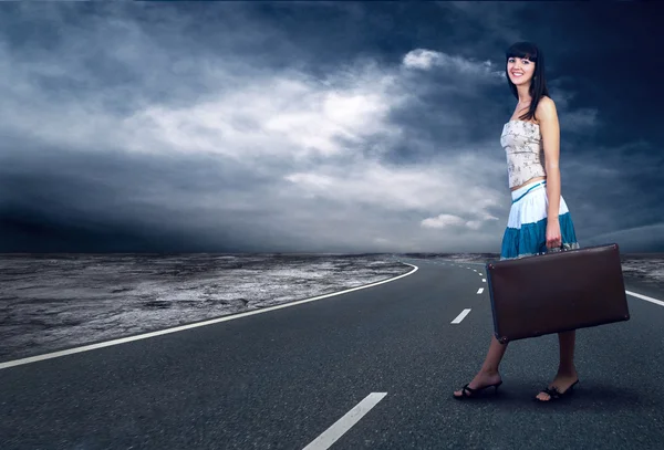 Giovane donna in attesa sulla strada con il suo bagaglio vintage — Foto Stock