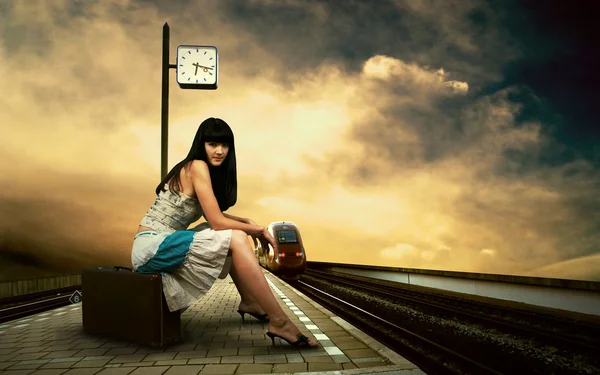 Τρένο περιμένει κορίτσι στην πλατφόρμα του σιδηροδρομικού σταθμού — Φωτογραφία Αρχείου