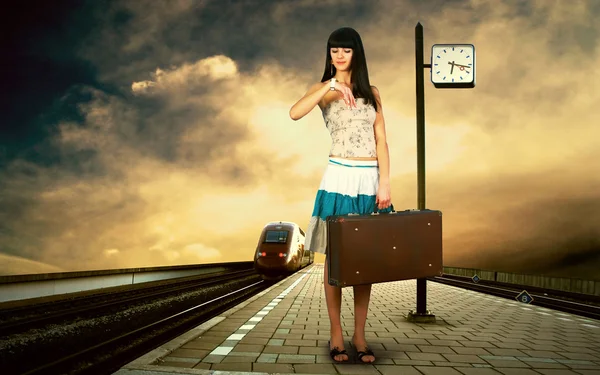 Flicka väntar tåg på plattformen av järnvägsstation — Stockfoto