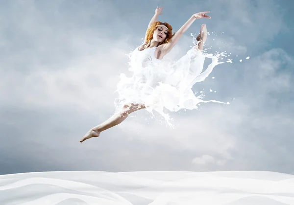 Sprong van ballerina met jurk van melk — Stockfoto