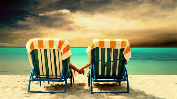 Πίσω όψη ενός ζευγαριού σε μια χαλαρωτική ξαπλώστρα στην παραλία — Φωτογραφία Αρχείου