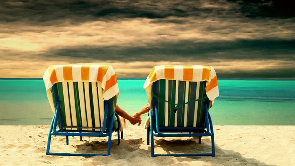 Πίσω όψη ενός ζευγαριού σε μια χαλαρωτική ξαπλώστρα στην παραλία — Φωτογραφία Αρχείου