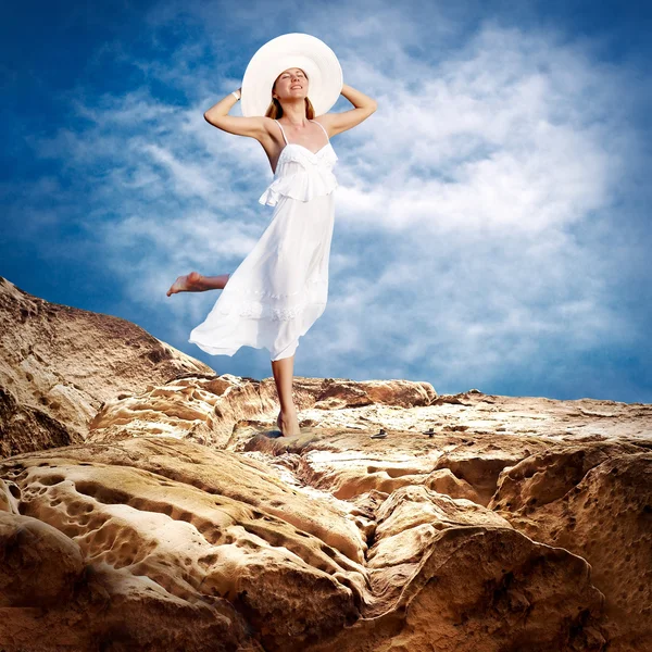 Bella ragazza in bianco sulla manutenere sotto il cielo con le nuvole — Foto Stock