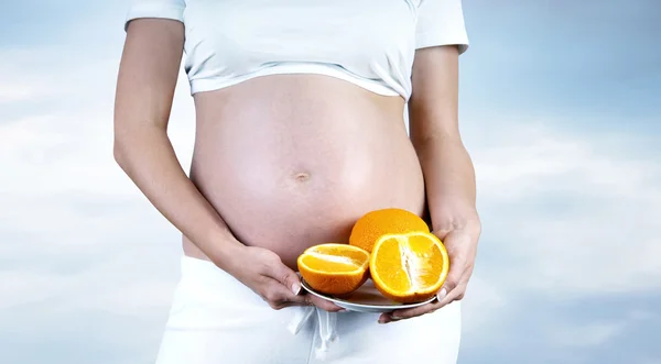 Щастя вагітних жінок в білому з апельсином — стокове фото