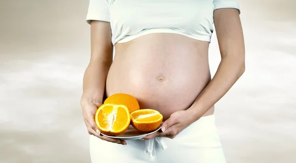 Έγκυες γυναίκες την ευτυχία στο λευκό με πορτοκαλί — Φωτογραφία Αρχείου