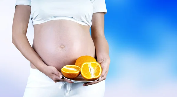 Bonheur femmes enceintes dans le blanc avec de l'orange — Photo