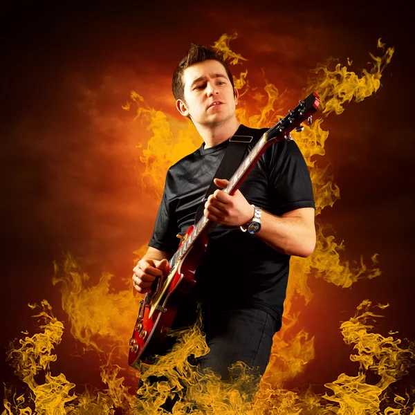 Rock gitarist te spelen op de elektrische gitaar rond brand vlammen — Stockfoto