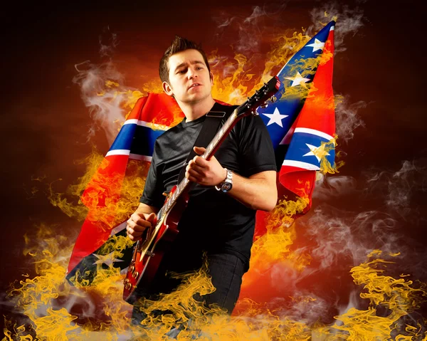 stock image Rock guitarist play on the electric guitar around fire flames