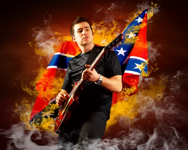 stock image Rock guitarist play on the electric guitar around fire flames