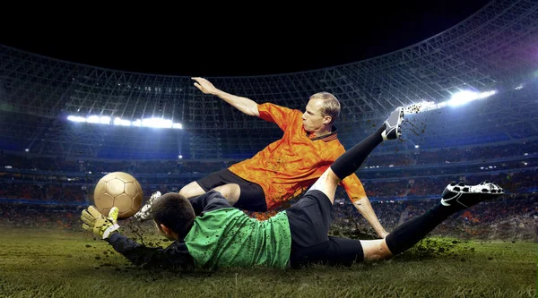 Piłkarz i skok bramkarza na boisku stadionu — Zdjęcie stockowe