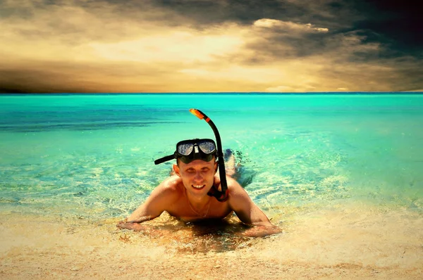 Glad ung man med snorkling på en strand — Stockfoto