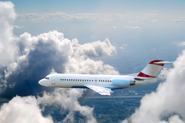 Lentokone lentää taivaalla pilvet — kuvapankkivalokuva