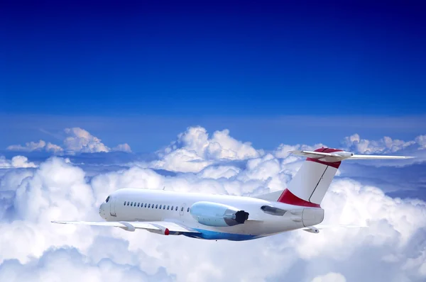 Lentokone lentää taivaalla pilvet — kuvapankkivalokuva