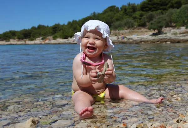 Menina brincando com seixos na praia do Adriático na Croácia — Fotografia de Stock