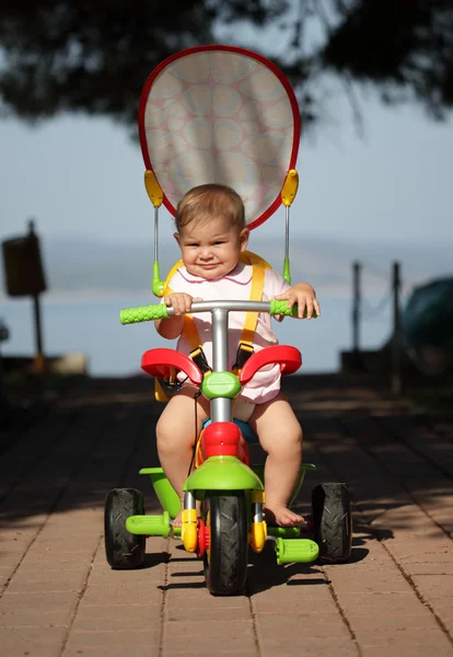 Meisje van de baby op haar eerste fiets — Stockfoto