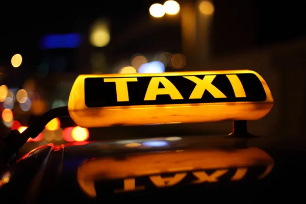 Sinal de táxi amarelo à noite — Fotografia de Stock