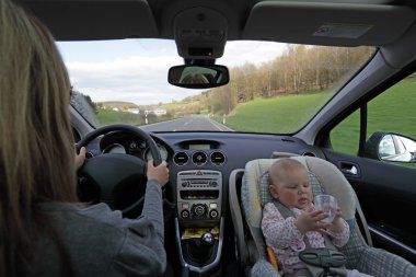 Mother driving car with the baby clipart