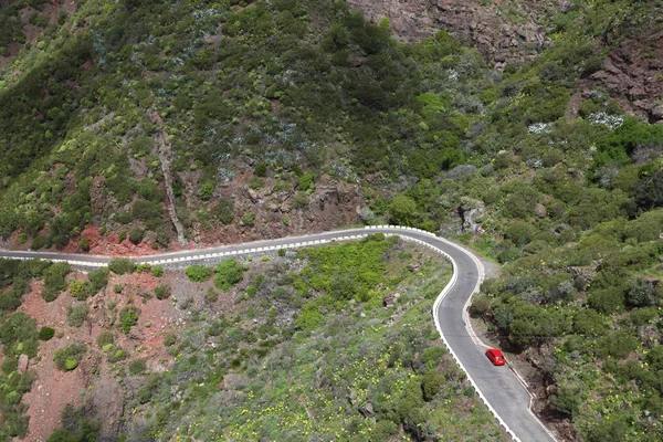 Гірська звивиста дорога з червоним автомобілем — стокове фото