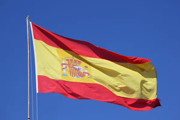 Flaga Hiszpanii przeciw błękitne niebo — Zdjęcie stockowe