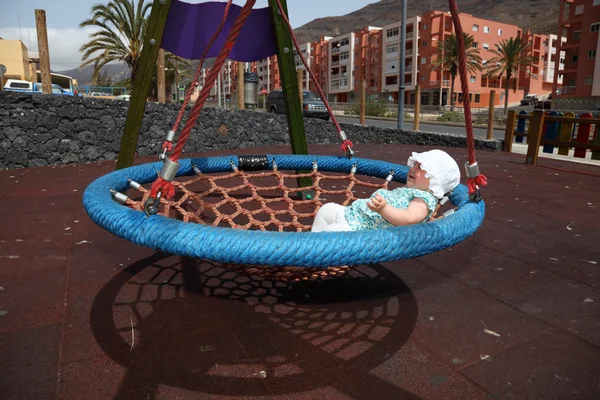 Happy baby girl in a swing — Stock Photo, Image