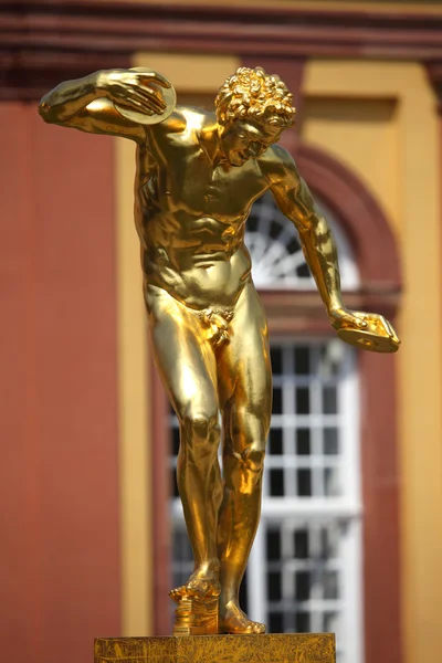 ディスクの投げる人の運動選手を示す古代ギリシャの彫像の黄金のレプリカ — ストック写真