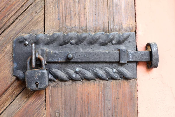 Old rusty padlock at a wooden door — Stock Photo, Image