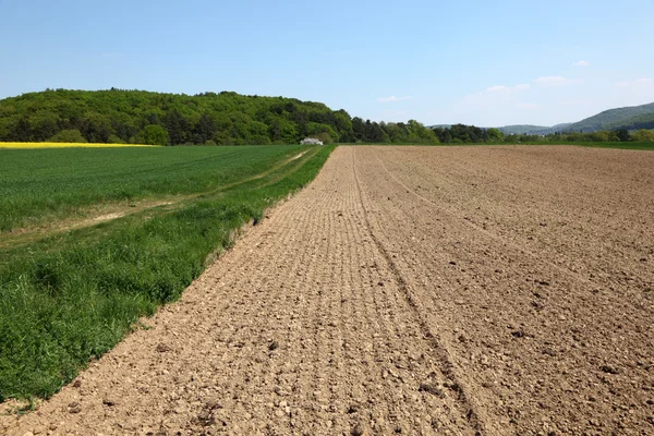 Paisagem rural - arado, campo e um prado — Fotografia de Stock