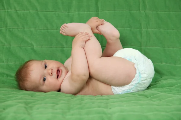 Söt baby flicka som leker med hennes fötter — Stockfoto