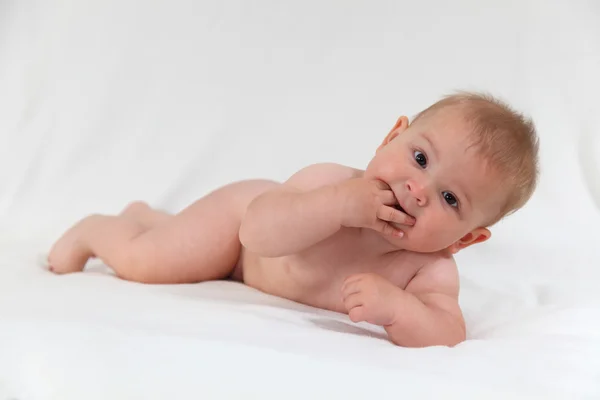 Şirin bebek yatakta parmak emme — Stok fotoğraf