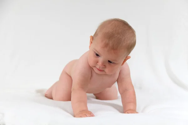 Niedliches Baby krabbelt im Bett — Stockfoto
