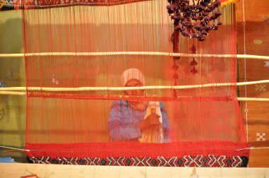 Berber woman weaving a carpet clipart