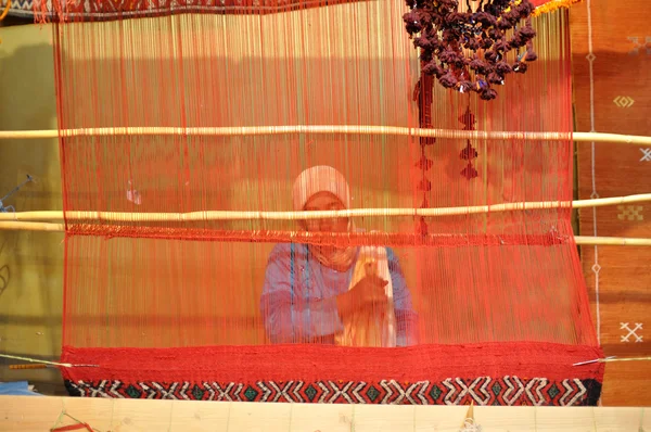 Берберская женщина плетёт ковер — стоковое фото