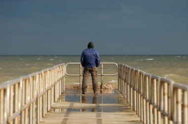 Lonely man on the pier clipart